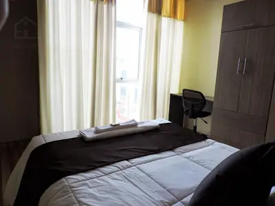 a bedroom with a large bed with a window at EmbajadaWanka in Huancayo