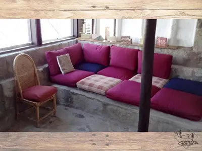 a pink couch and a chair in a room at Las Cabañas de Tarii in Cieneguilla