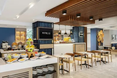 a restaurant with tables and chairs and a kitchen at Courtyard by Marriott Lima Miraflores in Lima