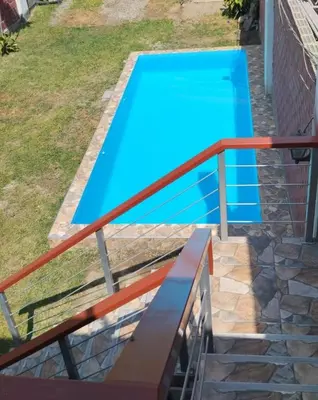 a blue swimming pool with a metal rail at Casa Halcones Huachipa Familia & Eventos in Lima