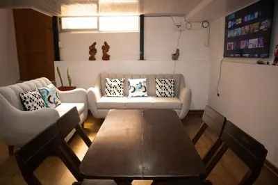 a living room with a table and two couches at La Almudena hogar tranquilo y acogedor in Cusco