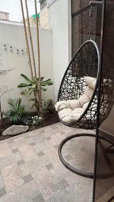 a swing chair sitting on a porch with a patio at Casa Amplia en Miraflores in Lima