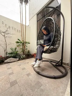 a woman sitting in a wicker chair at Casa Amplia en Miraflores in Lima