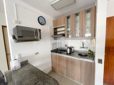 a small kitchen with a sink and a clock on the wall at Miraflores 1 habitación in Lima