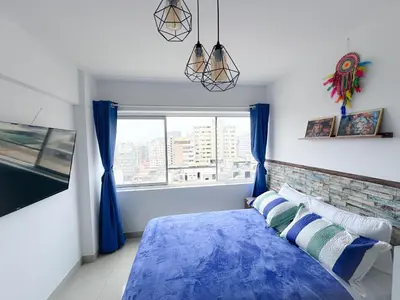 a bedroom with a blue bed and a window at Miraflores 1 habitación in Lima