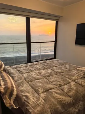 a bedroom with a bed and a view of the ocean at Elegante Departamento vista al mar en Lima in Lima