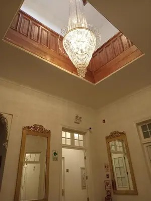 a ceiling with a chandelier in a room with two mirrors at Colville Hospedaje, a 1 cuadra de la plaza mayor de lima in Lima