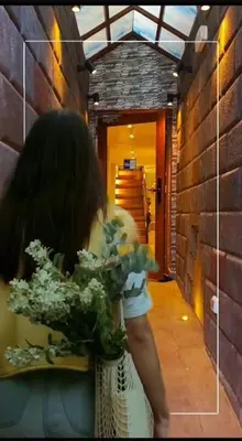 a woman holding a bunch of flowers in a hallway at Hotel Boutique PLAZA GIBAJA in Ollantaytambo
