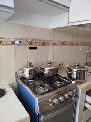 a kitchen with a stove with three pots on it at Apartamento entero en Ayacucho in Ayacucho