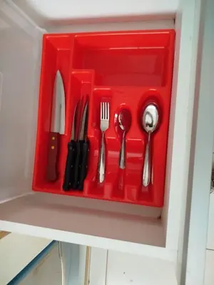 a red plastic tray with utensils in a drawer at Apartamento entero en Ayacucho in Ayacucho
