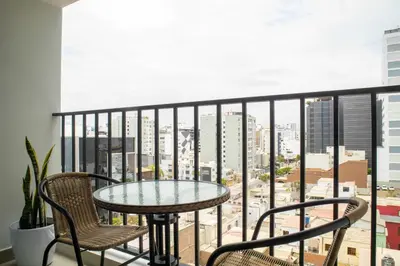 a table and chairs on a balcony with a view of the city at Aguirre By Wynwood House in Lima