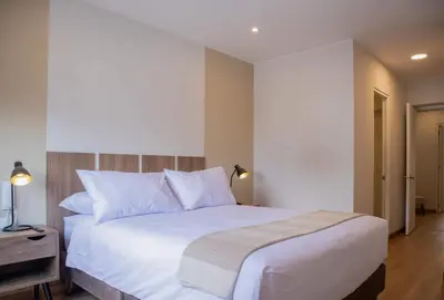 a bedroom with a large bed with white sheets and pillows at Aguirre By Wynwood House in Lima