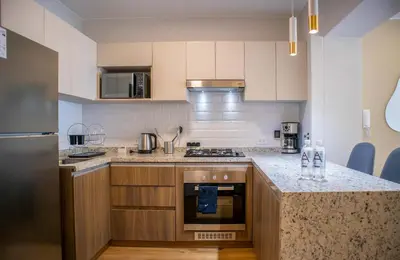 a kitchen with wooden cabinets and a counter top at Aguirre By Wynwood House in Lima