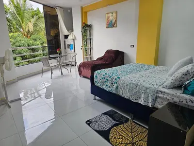 a bedroom with a bed and a table and a balcony at PIERO HOUSE - La Merced in La Merced