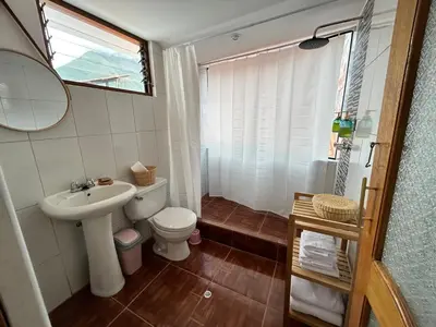 a bathroom with a sink and a toilet and a mirror at La Maison Samaï in Urubamba
