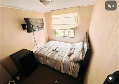 a small bedroom with a bed and a television at Katari Home Peru in Lima