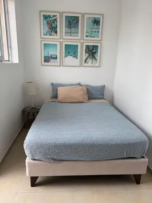 a bed in a white room with pictures on the wall at Casa Chocaya Playa Campo in Fundo Copacabana