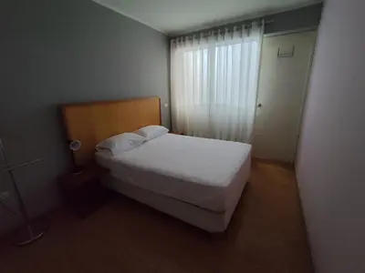 a small bedroom with a bed and a window at Apartamento Limas Airport in Lima