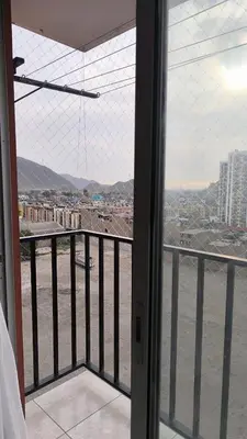 a room with a balcony with a view of a city at apartment Campoy for tourist in Lima