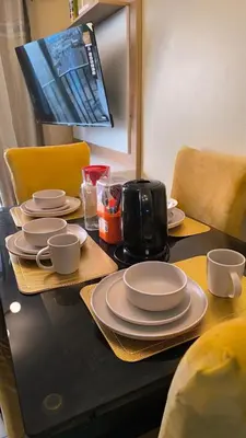 a table with plates and cups and a coffee maker at apartment Campoy for tourist in Lima