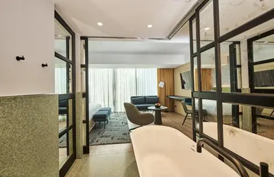 a hotel room with a bathtub and a living room at Hotel Indigo Lima Miraflores by IHG in Lima