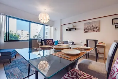 a dining room with a glass table and chairs at GRM302 Apt Moderno 2 DRM with KING Bed in Miraflores in Lima