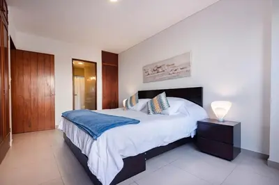a bedroom with a large bed with a blue blanket at GRM302 Apt Moderno 2 DRM with KING Bed in Miraflores in Lima