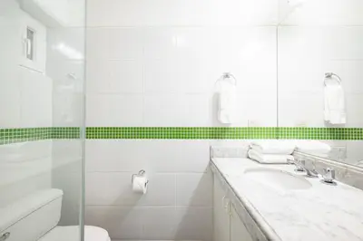 a white bathroom with a sink and a shower at M1001 - Malecon Seaview 2BDR Miraflores in Lima