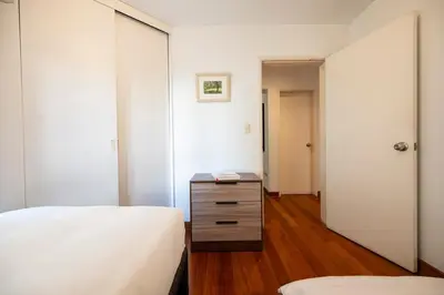 a bedroom with two beds and a dresser with a mirror at M1001 - Malecon Seaview 2BDR Miraflores in Lima