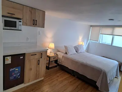 a small bedroom with a bed and a microwave at Venue Apartments in Lima