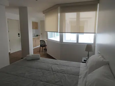 a bedroom with a large bed and a window at Venue Apartments in Lima