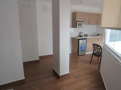 a kitchen with a table and a chair in a room at Venue Apartments in Lima