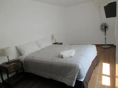 a bedroom with a large bed and a television at Venue Apartments in Lima