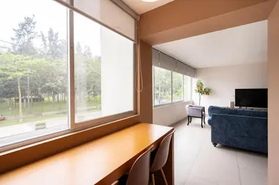a room with a desk and a large window at Reducto - Beautiful 3 BRD Front of Miraflores biggest Park in Lima
