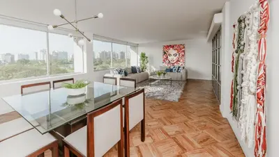 a dining room with a glass table and a couch at Romanet - Depa Premium con Vista al Golf in Lima