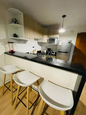 a kitchen with a counter and two stools at Apartamento moderno en San Miguel in Lima
