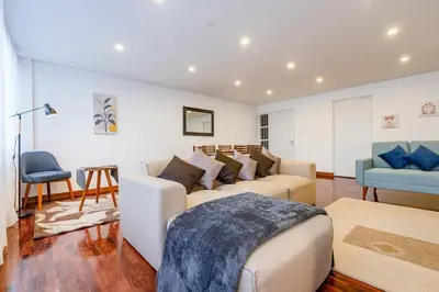 a living room with a couch and a chair at Benavides - Amplio departamento funcional de 3 hab en Av Principal in Lima