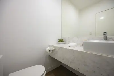 a white bathroom with a sink and a toilet at Balta - Apartment with Panoramic View in Kennedy Park in Lima