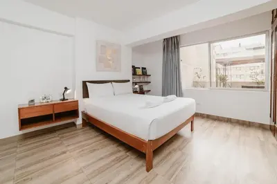 a white bedroom with a bed and a window at GRM308 Bright 2BR with BIG Terrace in Heart of Miraflores in Lima