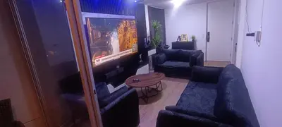 a living room with two blue couches and a tv at Dpto de Playa Miramar San Bartolo in San Bartolo