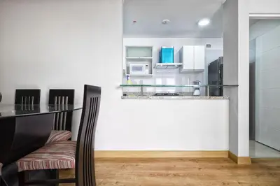 a kitchen with a counter and a table with chairs at Wasi Apartment Pardo in Lima