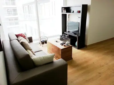 a living room with a couch and a tv at Wasi Apartment Pardo in Lima