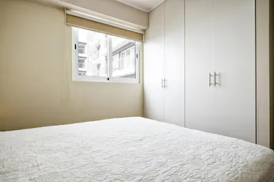 a bedroom with a white bed and a window at Wasi Apartment Pardo in Lima
