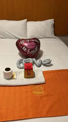 a bed with a heart shaped pillow and a pair of scissors at hospedaje isla bonita Perú in Huachipa Hacienda