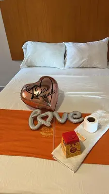 a bed with a hot dog and a box on it at hospedaje isla bonita Perú in Huachipa Hacienda