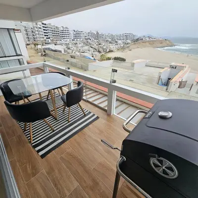 a balcony with a table and chairs and a view of the beach at Departamento amplio en punta hermosa frente al mar in Punta Hermosa