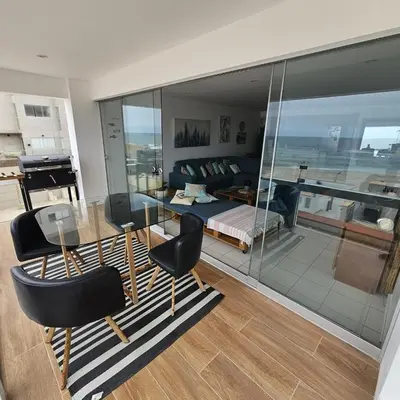 a living room with a glass table and a bedroom at Departamento amplio en punta hermosa frente al mar in Punta Hermosa