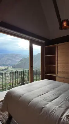 a bedroom with a large bed and a large window at Casa Catahuasi , Sacred Valley ,Urubamba,Cusco, Peru in Urubamba