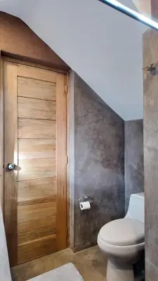 a bathroom with a toilet and a wooden door at Casa Catahuasi , Sacred Valley ,Urubamba,Cusco, Peru in Urubamba