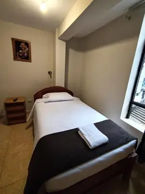 a bedroom with a bed in a room with a window at Kuntur House Machupicchu in Machu Picchu